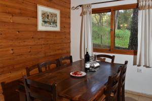 uma sala de jantar com uma mesa de madeira e cadeiras em Zimmers at the Forest em Amirim