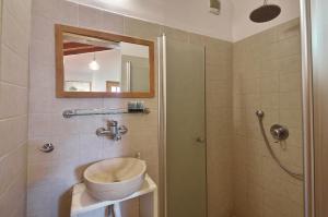 a bathroom with a sink and a shower at Zimmers at the Forest in Amirim