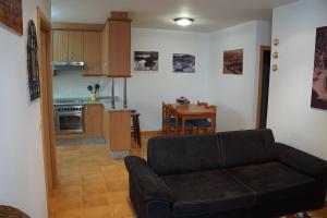 sala de estar con sofá y cocina en apartamento do curro, en Muros