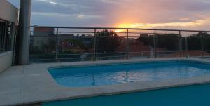 een zwembad op een balkon met de zonsondergang op de achtergrond bij Suites Foz O Porto in Porto
