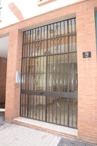 una puerta de cristal con barras de hierro en un edificio de ladrillo en habitacion centro historico malaga, en Málaga