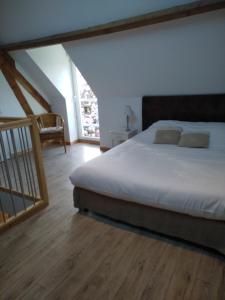a bedroom with a large bed and a staircase at L'Heure Bleue gîtes et chambres d'hôtes in Givenchy-en-Gohelle