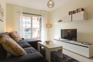 ein Wohnzimmer mit Sofa und Fernseher in der Unterkunft Precioso Apartamento la Marina in Rincón de la Victoria