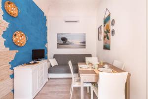 a dining room with a table and a couch at Casa Vacanza Teti in Marina di Ragusa
