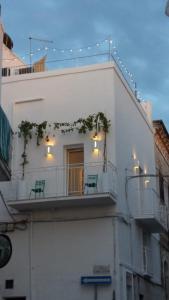 - un bâtiment blanc avec deux bancs sur un balcon dans l'établissement L'Angolo di Ostuni - Home&Terracex4, à Ostuni