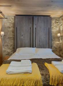 a bedroom with a large bed with two yellow beds at Le Chalet des Boisses, Luxury Ski-In Ski-Out Chalet for 12 in Tignes