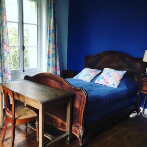 a bedroom with a bed and a table and a window at Moulin de Battereau - Jardin & Verger - 9km d'Amboise in Saint-Martin-le-Beau