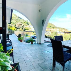 un patio con tavolo e sedie e un balcone. di Hotel Bahamas a Giglio Porto