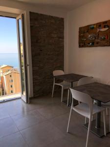 two tables and chairs in a room with a window at Cinque Terre Coast to Coast in Riomaggiore