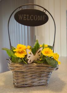 a basket of flowers with a welcome sign on it at Urhanen in Gedser