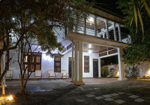 ein Haus mit Stühlen und einer Veranda in der Nacht in der Unterkunft Aura City Hostel in Anuradhapura