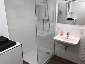 a white bathroom with a sink and a shower at Nürnberg Nord in Nuremberg