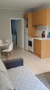 a kitchen with a couch and a chair in a room at Athenian apartment with garden, near metro station Chalandri Nu 3 in Athens
