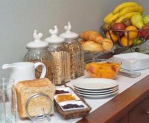 una mesa con jarras y platos de comida y fruta en Tuscany Gardens Motor Lodge, en Nelson