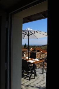 uma mesa com um guarda-chuva num deque em "Country House il Brolo" em Polpenazze del Garda