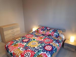 1 dormitorio con 1 cama con un edredón colorido y 2 velas en Le Bellevue, en Colmar
