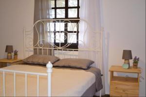 a bedroom with a white bed and a window at Casa Natura in Ammouliani