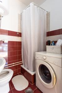 a bathroom with a washing machine and a toilet at S&N Apartments Nis in Niš +13 photos
