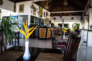a restaurant with a table and chairs and a bar at Kelapa Lovina Beach Villa in Lovina