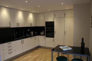 a kitchen with white cabinets and a table in it at Rera Alvor Deluxe Apartments in Alvor