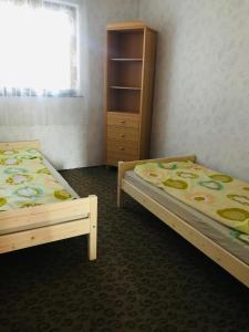 two twin beds in a room with a window at Jesolo Apartmanház in Balatonkeresztúr