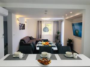 a living room with a table and a couch at HOLIDAY HVAR lux in Basina