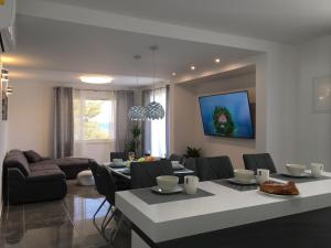 a dining room and living room with a table and chairs at HOLIDAY HVAR lux in Basina