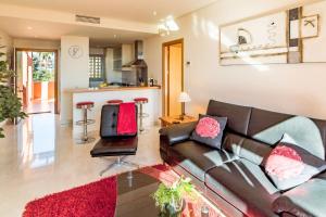 - un salon avec un canapé et un tapis rouge dans l'établissement Seaview Luxury Penthouse Apartment 24 hour security and Underground Parking, à Estepona