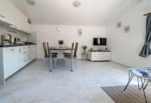a kitchen and dining room with a table and chairs at Apartment Podini in Brseč