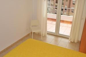 a room with a yellow rug and a chair and a window at Sesimbra Terrace Oasis in Sesimbra