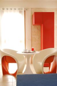 a room with a table and two chairs and a table and a table and chairs at Cave Bianche Hotel in Favignana