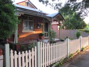 a white picket fence in front of a house at Acacia Cottage on Peel, Bathurst in Bathurst