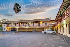 een gebouw met een auto geparkeerd op een parkeerplaats bij Prince of Wales Hotel in Wagga Wagga