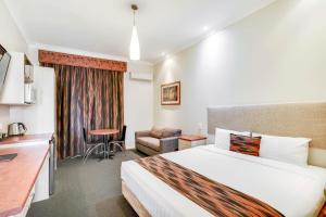 a hotel room with two beds and a television at Prince of Wales Motor Inn in Wagga Wagga