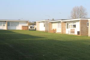 a group of houses with a grass yard at 78 Florida Holiday Park in Hemsby