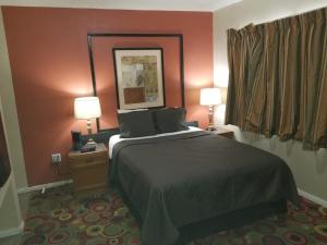a hotel room with a bed and two lamps at Western Motel in El Centro