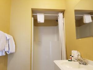 a bathroom with a sink and a toilet and a mirror at Western Motel in El Centro