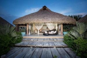 einen Pavillon mit einer Couch und einem Grasdach in der Unterkunft Samora Luxury Resort in Santa María Colotepec