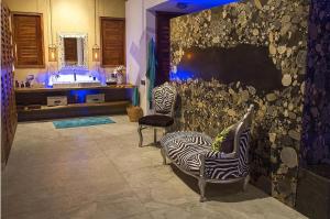 baño con 2 sillas de cebra y lavamanos en Samora Luxury Resort, en Santa María Colotepec