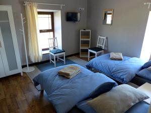 2 camas en una habitación con 2 sillas y TV en Garadice View Farm House, en Ballinamore