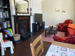 a living room with a fireplace and a red chair at Garadice View Farm House in Ballinamore