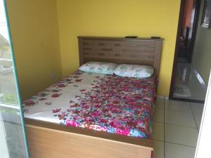 Un dormitorio con una cama con flores. en Quartos da lagoa en Cabo Frío