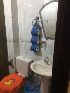 uma casa de banho com um WC, um lavatório e um espelho. em Quartos da lagoa em Cabo Frio