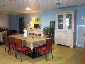 a dining room with a table and red chairs at Résidence VILLA DES MARAIS in La Chevrolière