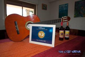 a guitar and two bottles of wine on a table at Etna Travellers B&B in Mascalucia