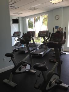 a row of exercise bikes in a gym with a clock at Hollywood apartment by the sea in Hollywood