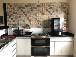 una cucina con fornelli e microonde di Apartamento Caiçaras a Belo Horizonte