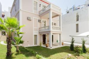 a large white house with a yard at La Canea Canvas 1 in Chania