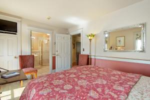 a bedroom with a bed and a desk and a mirror at After Eight Bed and Breakfast in Ronks