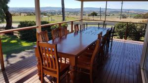 a wooden table and chairs on a deck with a view at 505 CONROD STRAIGHT MOUNT PANORAMA in Bathurst